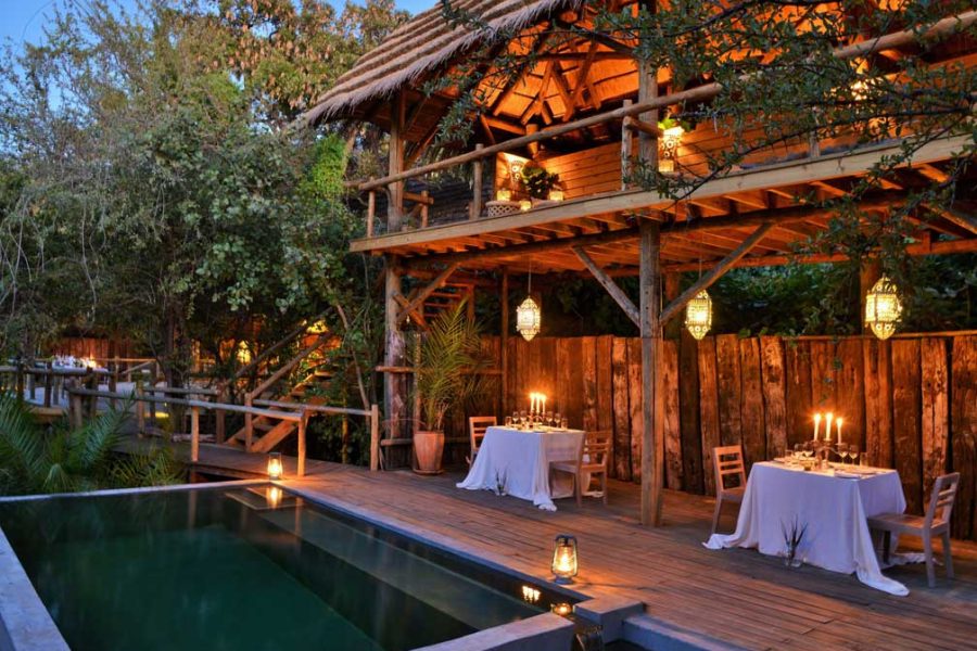Chobe Bakwena deck and pool lit by lanterns at dusk